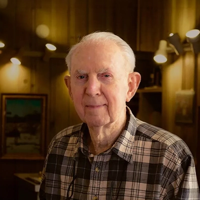 Chiropractor Robert “Bob” Wright Smiling In Rustic Room